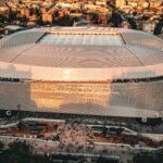 Stunning aerial shot of the Santiago Bernabéu Stadium, Madrid during sunset with bustling cityscape.